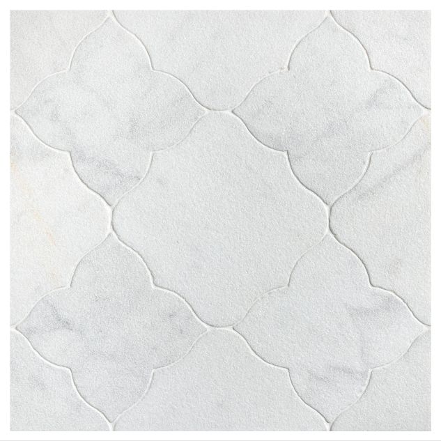 The Angelique Crest + Flower waterjet tile module in Mugla White marble, seen in a tumbled and bush-hammered finish.